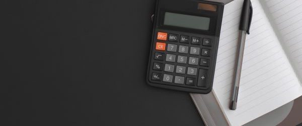 calculator-notebook-pen-on-black-leather--e1735247431992.jpg