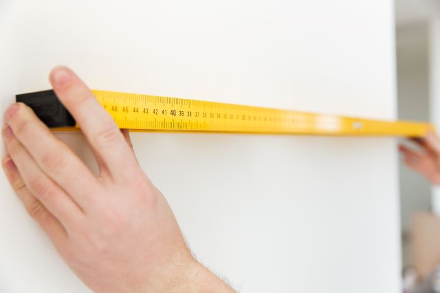 Close up of a man's hand holding a tape measure