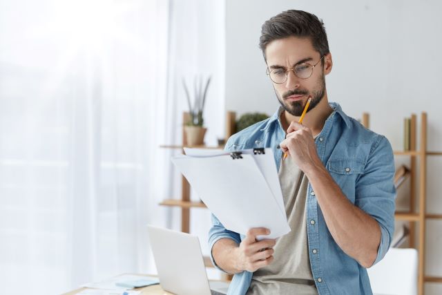 Male homeowner looking over checklist or list of questions