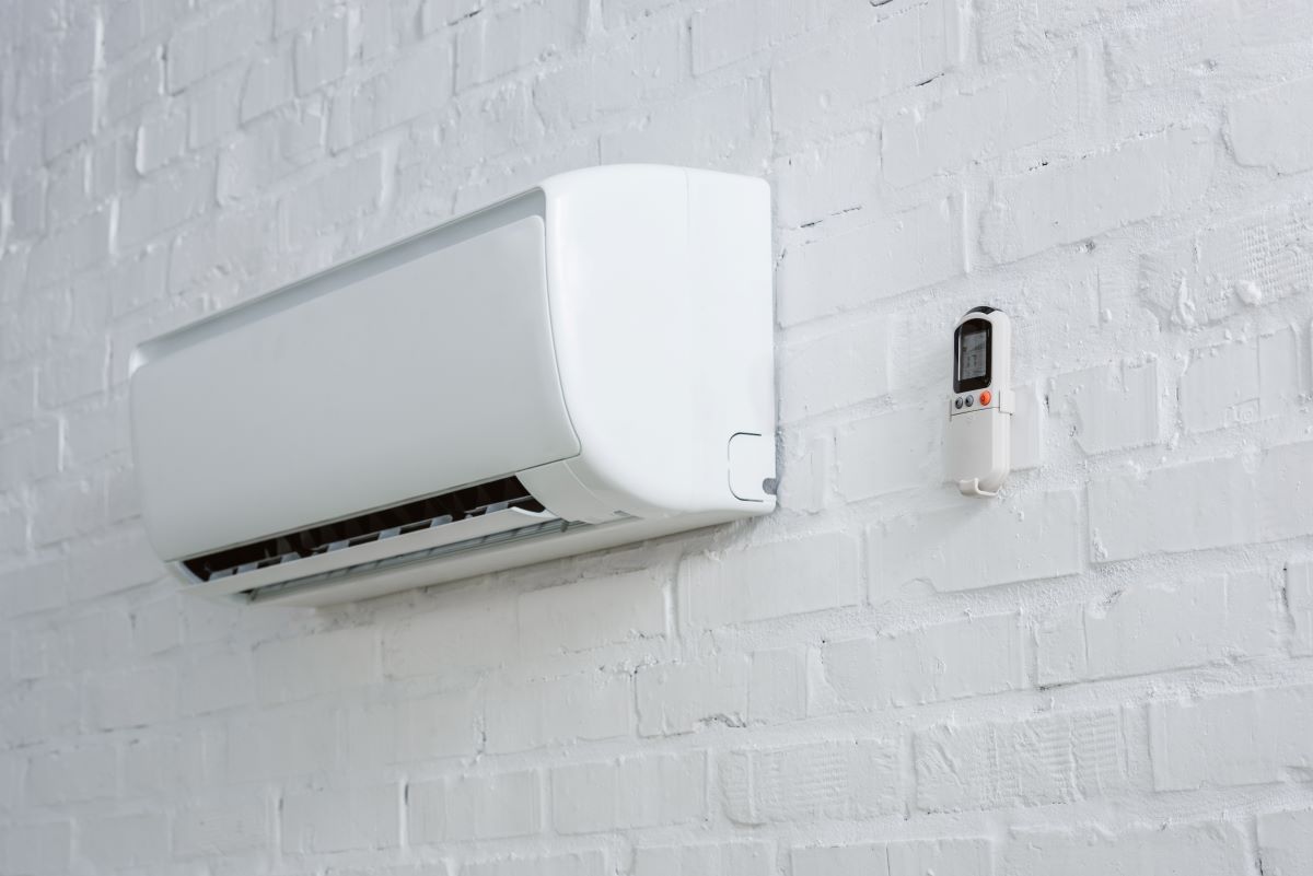 air-conditioner-hanging-on-white-brick-wall